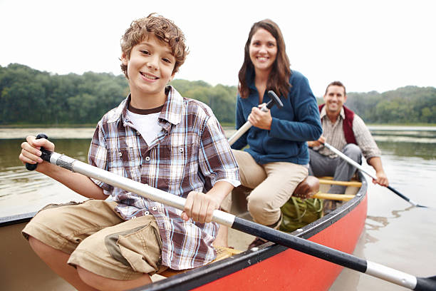 Cute young family canoeing on the lake with a smile